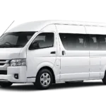 Toyota Hiace Commuter putih tampak serong depan dan samping untuk layanan sewa Hiace Bandung dengan driver profesional